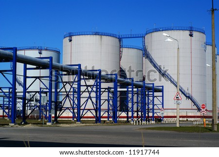 industrial pipelines and storage tanks against blue sky