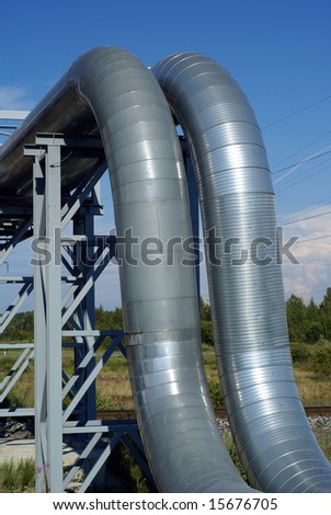 industrial pipelines on pipe-bridge and electric power lines  against blue sky