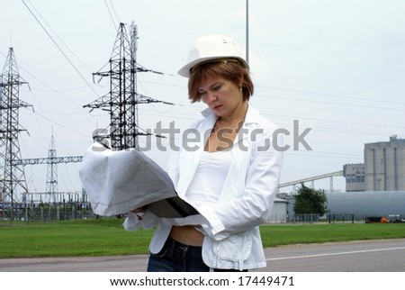 Woman engineer or architect with white safety hat drawings and electrical towers structure on background