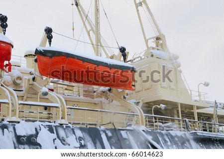 Lifeboat on the side of the ship. In snow.