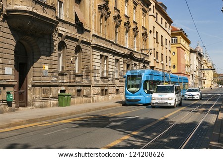 ZAGREB, CROATIA - AUGUST 21: People travel along city street with old houses by tram and taxi in Zagreb, Croatia on August 21, 2012. Zagreb Tram run by the Zagrebacki elektricni tramvaj (ZET).