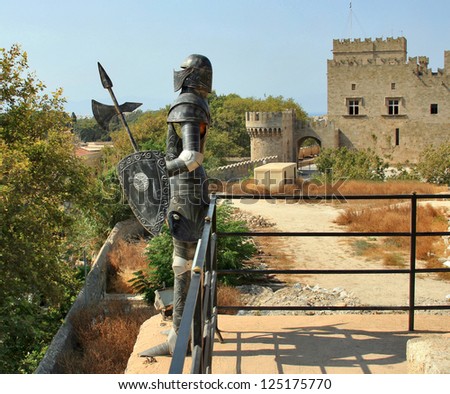 A suit of armor of the knights on the Greek island of Rhodes. Grand Master palace on background.