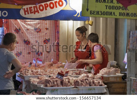 ODESSA, UKRAINE - AUGUST 25: Unknown middle age women vendors in red aprons sells poultry products to unknown buyers at the time of trade in the local food market on August 25, 2013 in Odessa, Ukraine