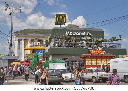 KIEV, UKRAINE - July 05: Cars parked and pedestrians walk along McDonald\'s and McFoxy fast food restaurants in front of Kiev Central Passenger Railway Station on July 05, 2013 in Kiev, Ukraine.