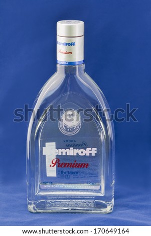 KIEV, UKRAINE - APRIL 30, 2012: Nemiroff Premium De Luxe vodka bottle against blue background. In 2006 Nemiroff became the second largest vodka producer in the world by sales, trailing only Smirnoff.
