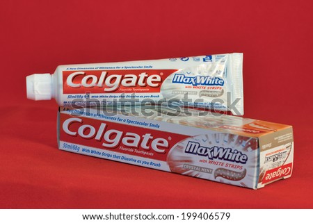 KIEV, UKRAINE - FEBRUARY 21, 2011: Colgate Max White fluoride toothpaste tube and pack against red background. Colgate is a manufacturer of a wide range of toothpastes, toothbrushes, and mouthwashes.