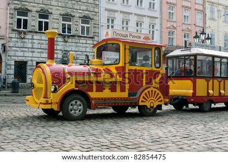 LVIV, UKRAINE - MARCH 11: Sightseeing car train waiting for tourists on Market Square on March 11, 2011 in Lviv, Ukraine. The square is rectangular, with two streets radiating out of every corner.