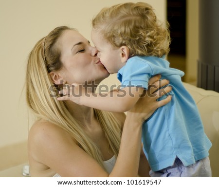 Beautiful caucasian mother kissing her cute son
