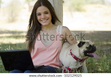 Happy latin woman spending time with her dog at the park