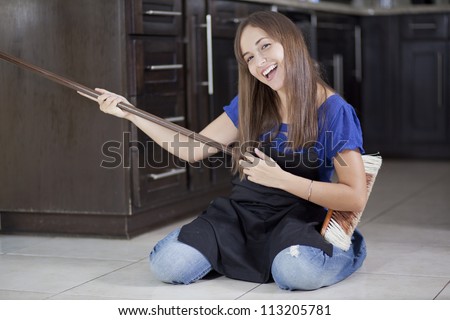 Cute hispanic housewife having fun while doing some house chores