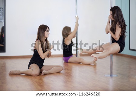 Pole fitness instructor and students during class