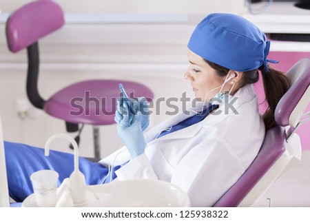 Pretty female dentist relaxing and listening to music at the dental office