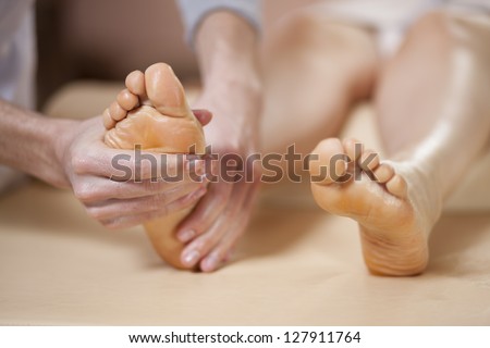 Male therapist giving a foot massage to a woman
