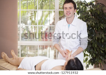 Male masseuse working with a female client at her home