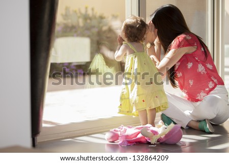 Mom And Daughter Looking Through The Window