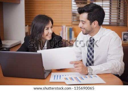 Young business colleagues flirting at the office while working together