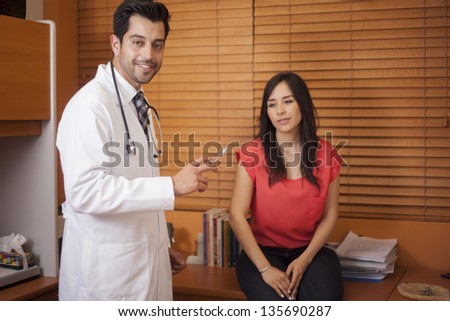 Handsome young doctor giving a vaccine to a female patient