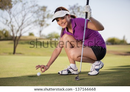 Beautiful young woman trying to cheat at golf