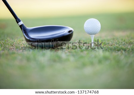 Closeup of a golf club and a golf ball ready for tee off