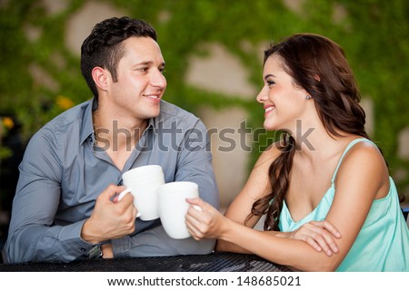 Pretty young couple having fun on their first date at a coffee shop