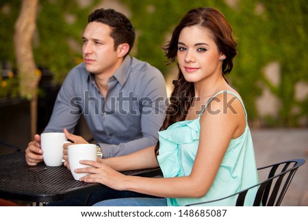 Cute young brunette drinking coffee on a first date