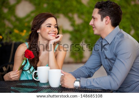 Beautiful girl just got a red rose from her boyfriend on a date at a cafe