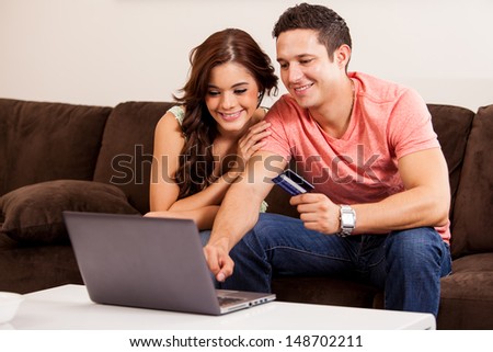 Happy Young Couple Booking A Vacation Trip Online Together With A Laptop Computer And A Credit Card