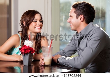 Cute Latin woman falling in love with a guy on a date at a restaurant