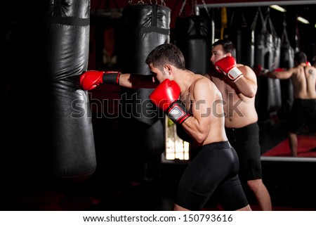 Latin Boxers doing some training on a punching bag at a gym