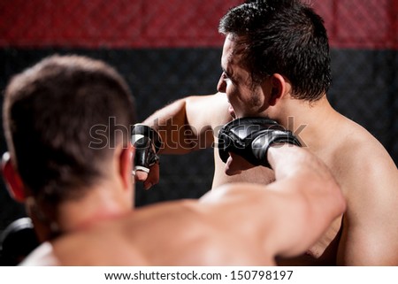 Point of view of a MMA fighter punching his opponent during a fight in a cage
