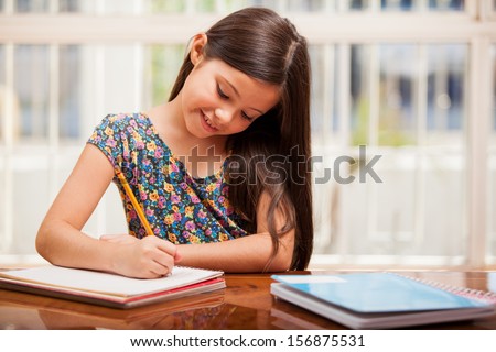 Pretty little girl enjoys learning and doing some homework