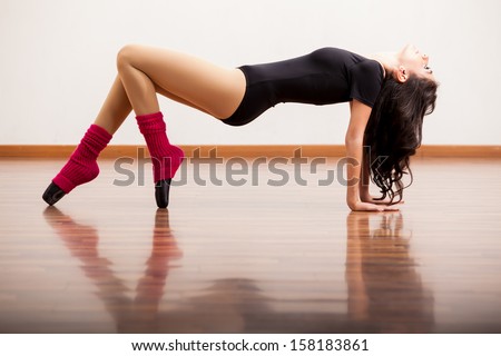 Gorgeous ballet dancer practicing some moves in the dance floor