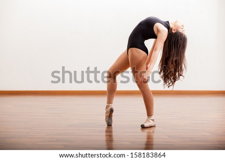 Sexy ballerina rehearsing a dance routine in a dance studio