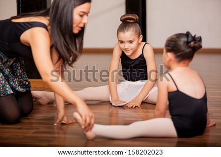 Pretty Hispanic little girls listening to her dance instructor directions during a dance class