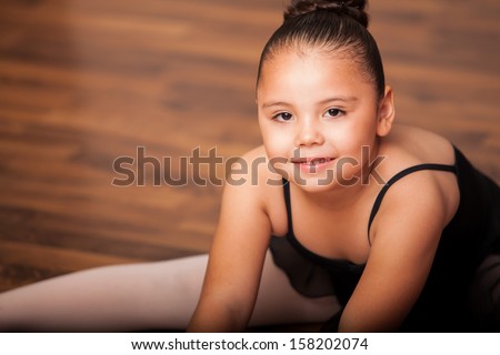 Portrait of a Hispanic and chubby little girl wearing a ballet outfit and smiling