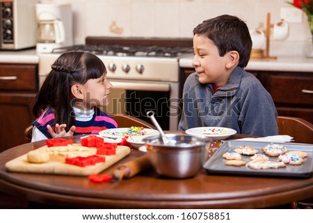 Happy brother and sister baking holiday cookies together