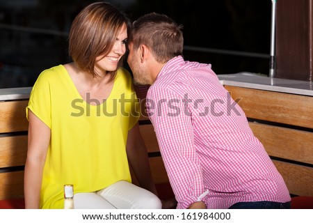 Young Caucasian man flirting with a woman while hanging out at a bar at night