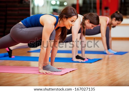 Beautiful young Hispanic women working out and enjoying their yoga class in a gym