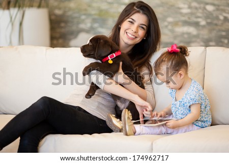 Cute young mom spending time with her daughter and a puppy Cute young mom spending time with her daughter and a puppy