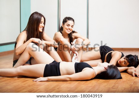 Cute and happy pole dancers taking a break from practice and having fun