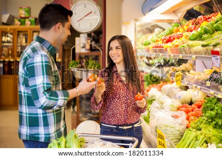 Young Latin newlyweds shopping together and buying some healthy food