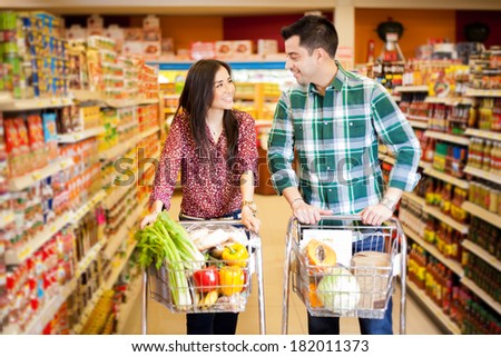 Young man and a woman flirting at the supermarket while they do their shopping
