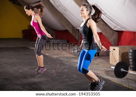 Pretty athletic girls using jump ropes for her workout in a gym