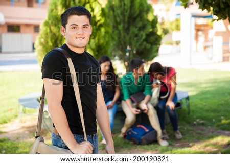 Good-looking high school student hanging out with some of his friends at school