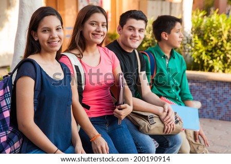 Group of four teenage friends hanging out in high school
