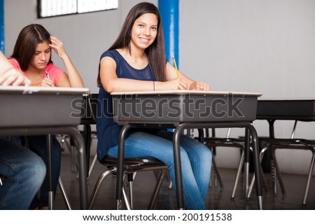 Pretty Latin teen during an admission test for high school. With some copy space.
