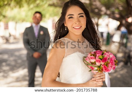 Portrait of a beautiful Latin bride with the groom standing behind her