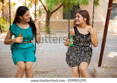 Beautiful teenage friends hanging out at a park and drinking soda