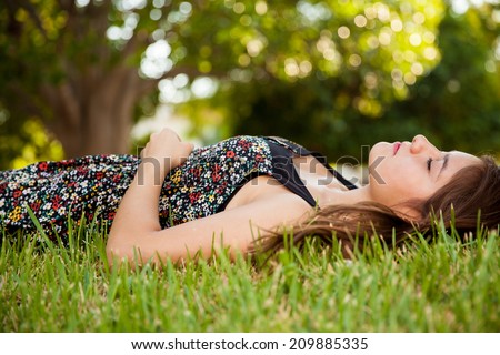 Gorgeous teen laying on the grass and taking a nap at a park