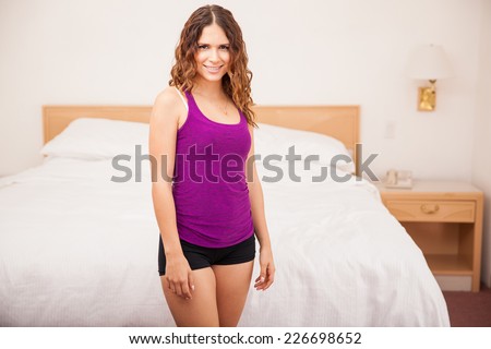 Gorgeous young woman wearing sleepwear and standing next to her bed ready to sleep